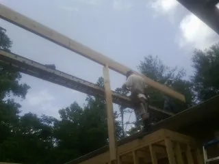 Carpenter setting a ridge beam over a new addition frame — Ice Dam Removal by Roofing Brothers in Tillman