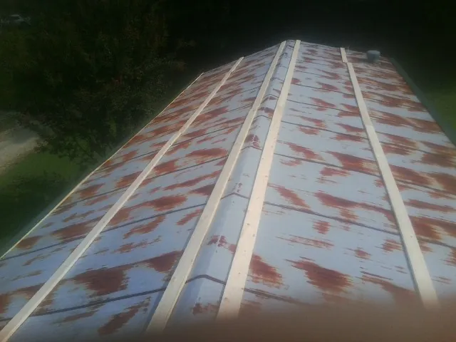 Rusted metal roof panels with new wood purlins before replacement — Storm Damage Roof Repair in Tillman by Roofing Brothers