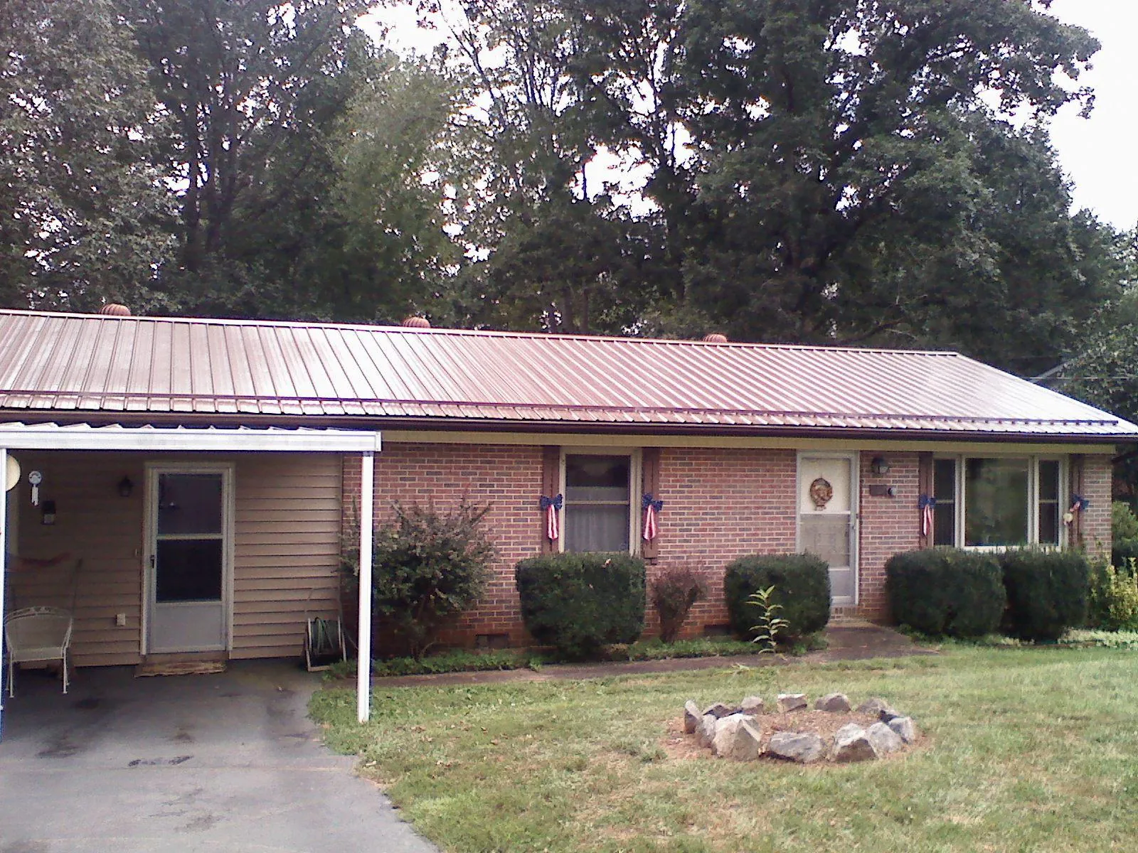 Bronze metal roof and carport on a brick ranch home — Roof Repair work by our crew in Tillman