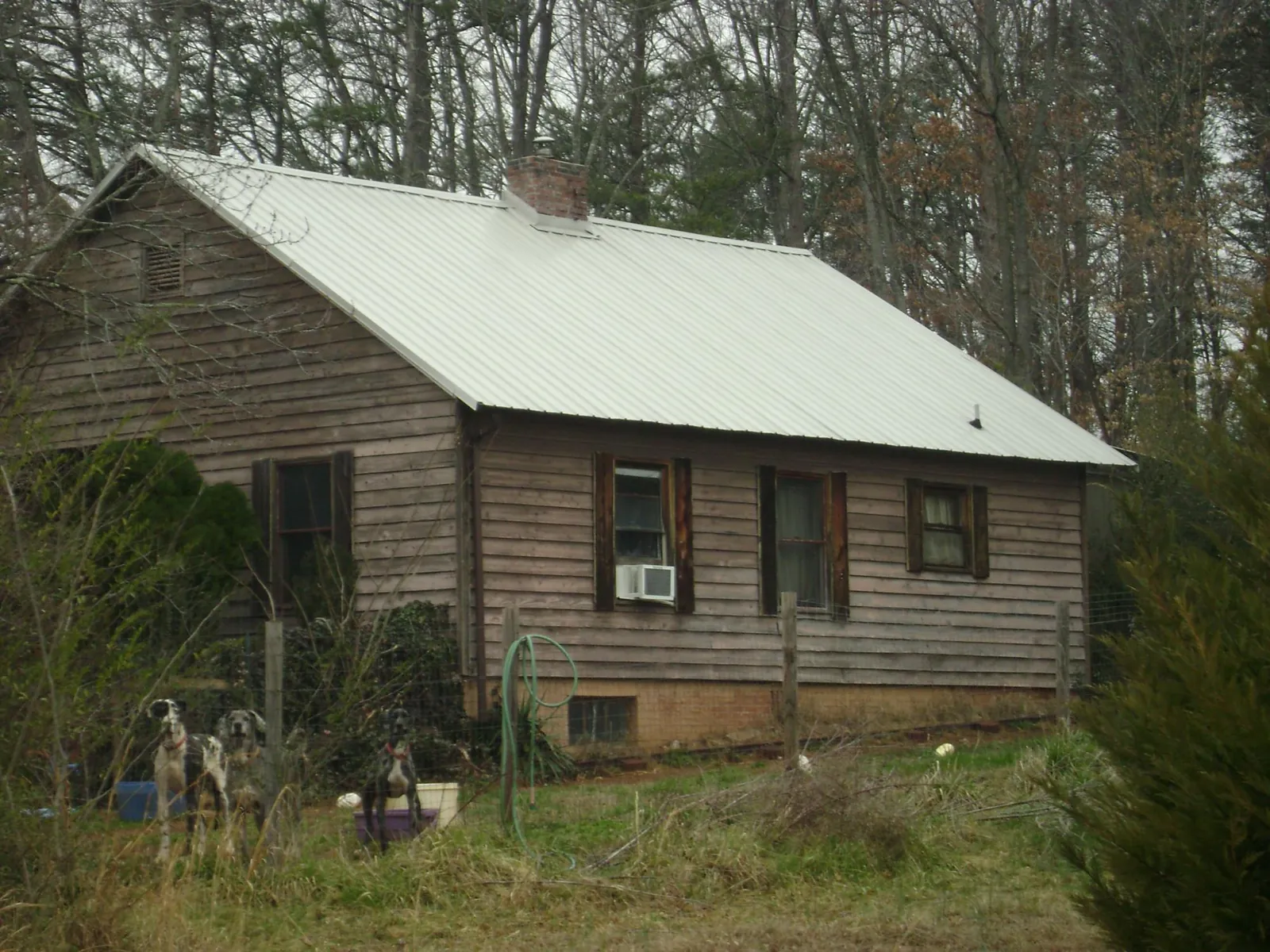 White metal roof on an old wood sided farmhouse, from a Metal Roof Installation job in Tillman
